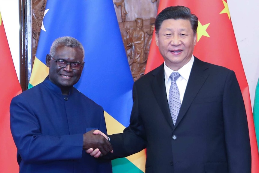 在北京，中国国家主席习近平与所罗门群岛总理乔杜里握手。
