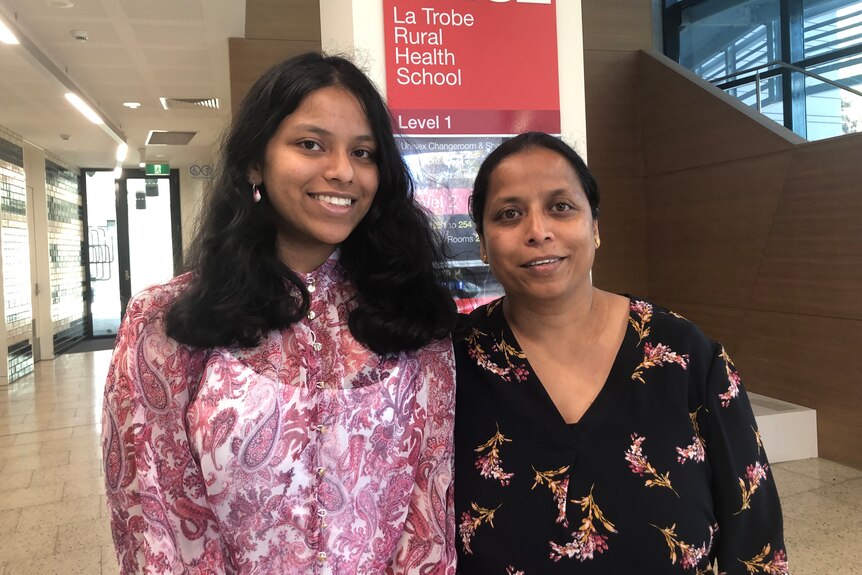 two Indian women smile at the camera