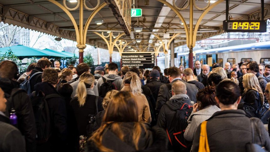 Commuters crowd on a platform at Flinders Street Station.