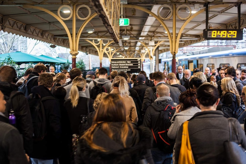 Commuters crowd on a platform at Flinders Street Station.