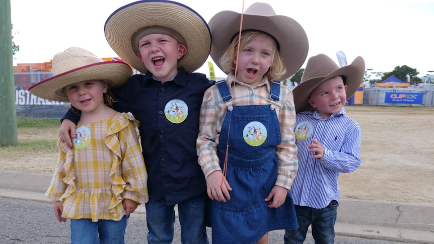 The Holland kids wearing big hats, jeans, overalls and boots.
