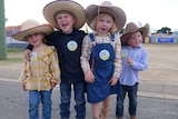 The Holland kids wearing big hats, jeans, overalls and boots.