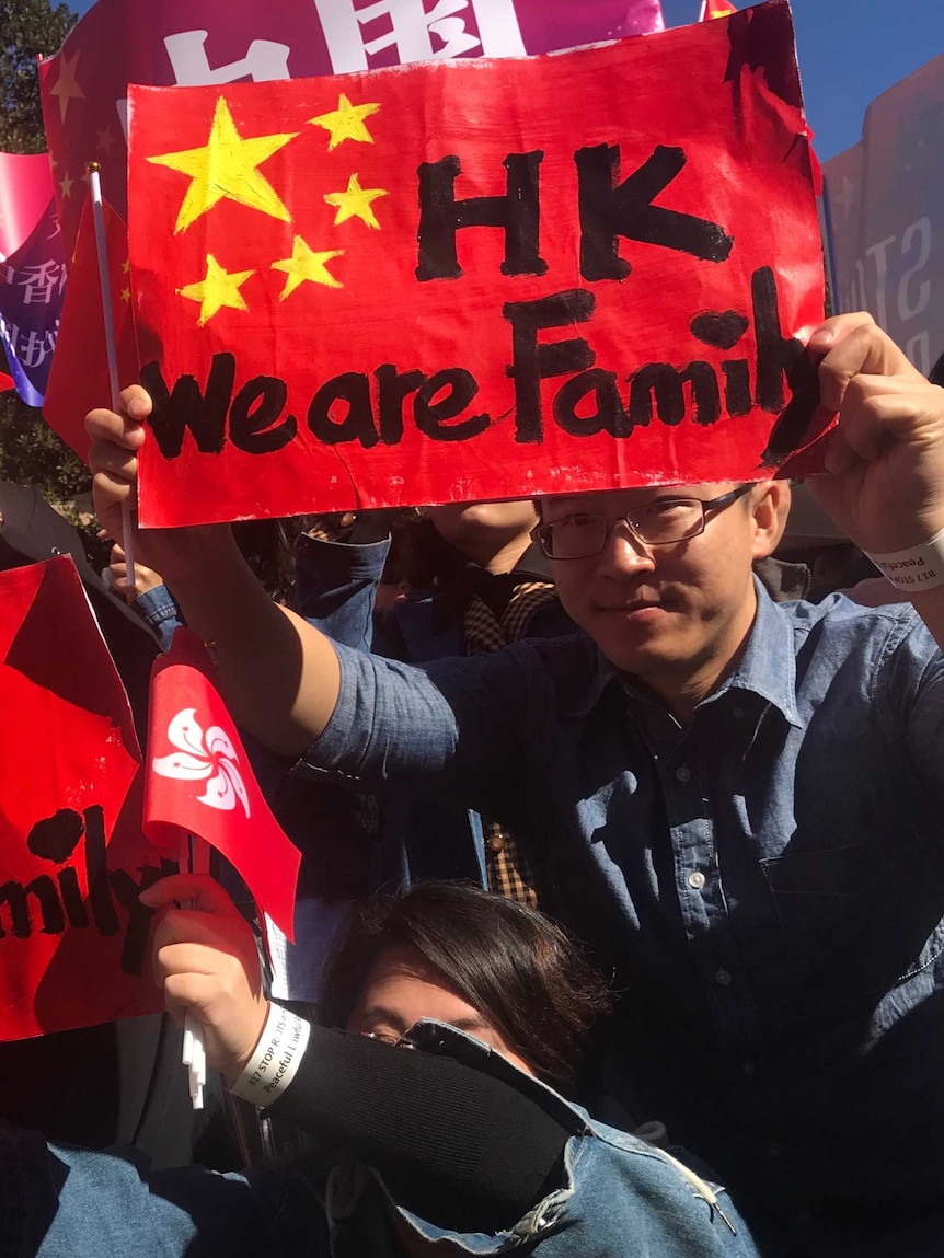 Several students hold up bright red signs