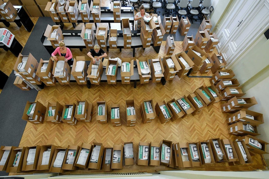 From above, you look down into an office room lined with boxes containing EU ballot papers as people pack them.