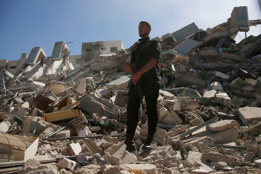 A policeman stands on rubble from a building housing AP office and other media in Gaza City.