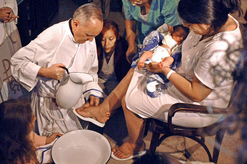 The archbishop of Buenos Aires, Cardinal Jorge Bergoglio, washes the feet of a unidentified woman.