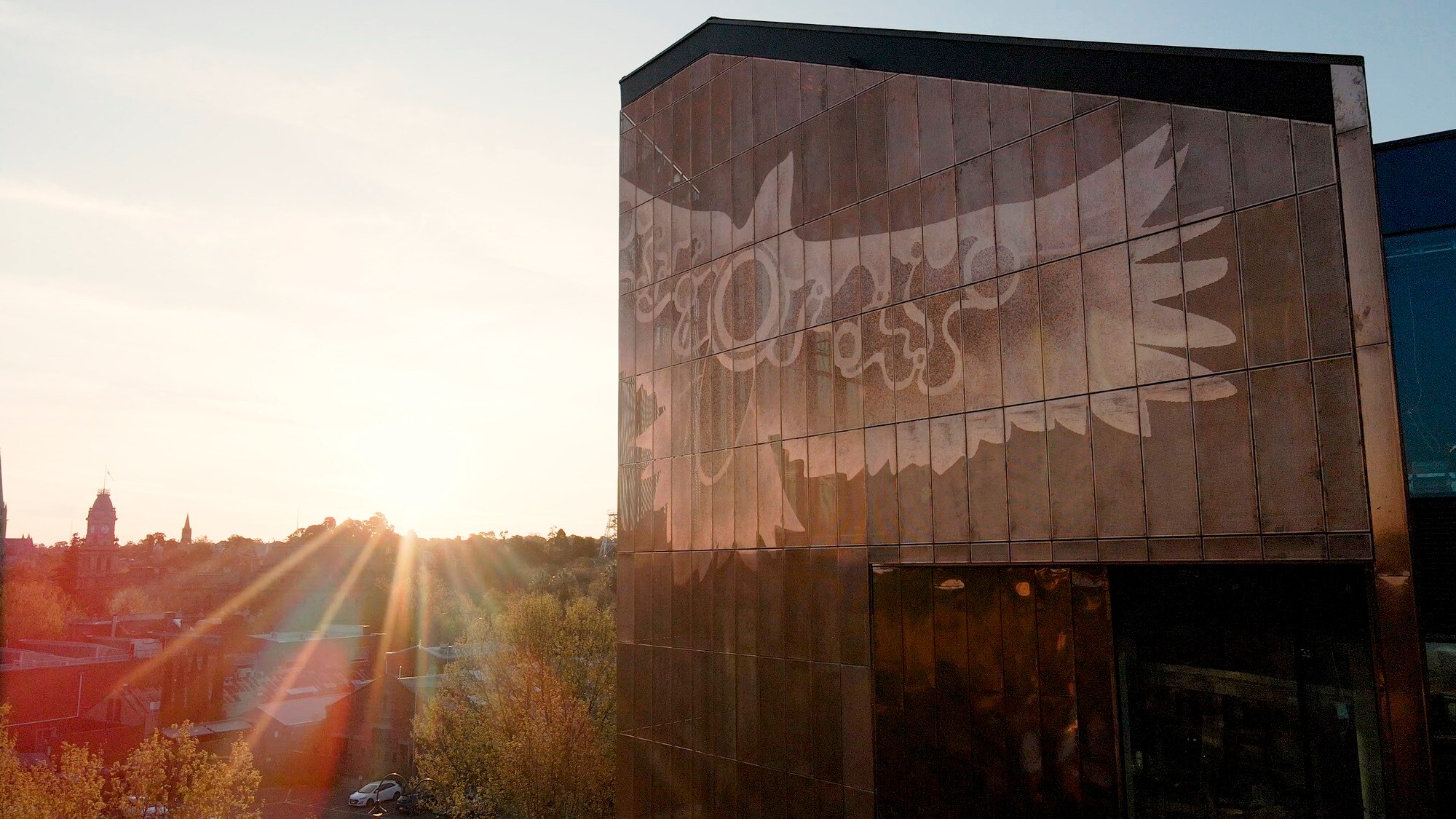An image of an eagle, wings extended and covered in indigenous designs, stretched across the top of a five storey building.