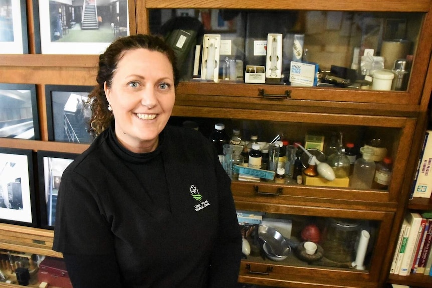 Amanda Wilson stands in front of a medical cabinet and smiles.