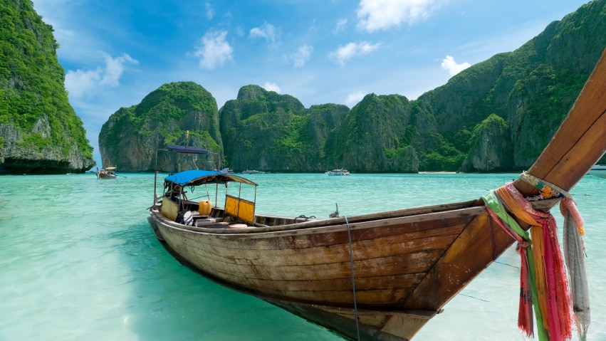 A crystal blue beach with a boat by the beach.