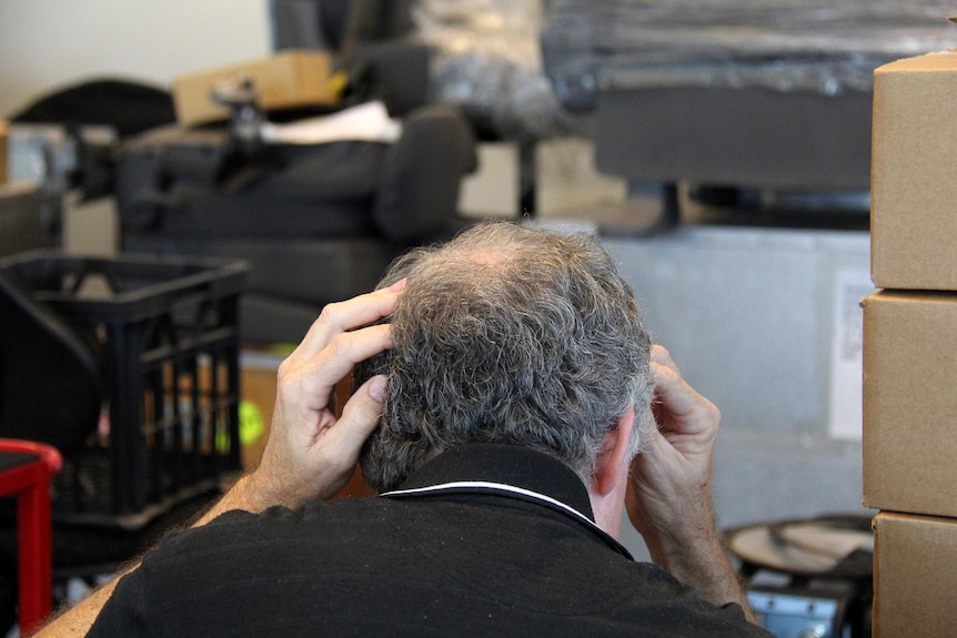 A small business owner, looking at his laptop, looking concerned