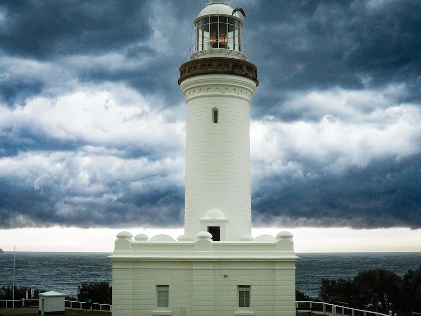 A lighthouse with storm clouds behind it.