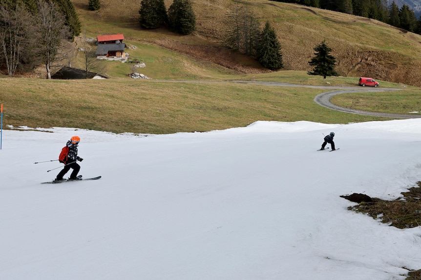 Picture of a two skier passing through a layer of artificial snow