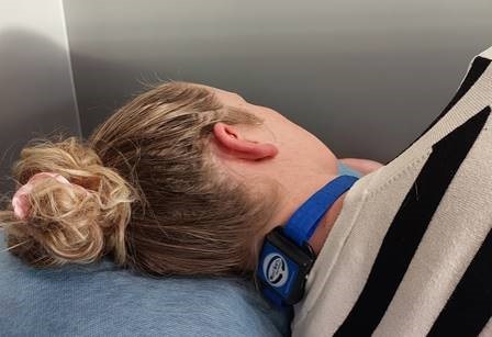 woman lying down viewed from behind wearing something around her neck