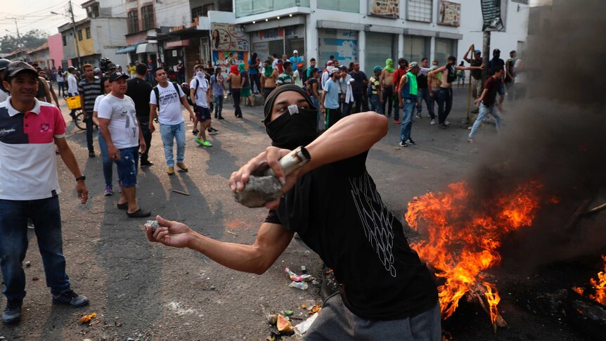 A masked man throws rocks during clashes with soldiers near Venezuela's border with Colombia.