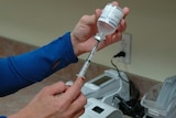 a female hand pulls up on a syringe