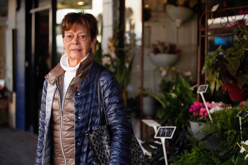 Woman standing in front of a flower shop.