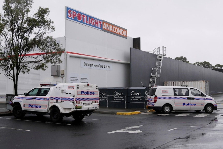 Police at scene where woman's body was found in a charity bin near a shopping centre at Burleigh.