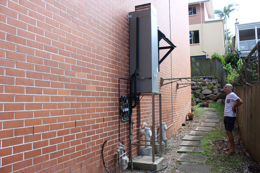 A hot water system set on a platform against a brick wall
