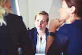 A woman across a table in a business meeting, for a story about unfair dismissal at work.
