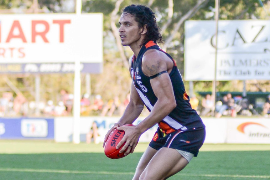 Cam Ilett carries the football in an NT Thunder jersey during a match.
