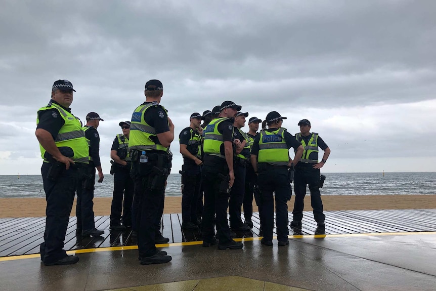 Police stand by the beach in St Kilda.