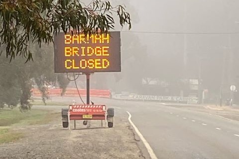 An electronic road sign, on the side of a highway, that says "Barmah Bridge closed".