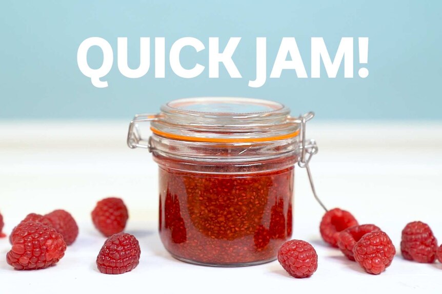 Close up of small jar filled with raspberry chia jam surrounded by fresh raspberries, accompanying our quick recipe
