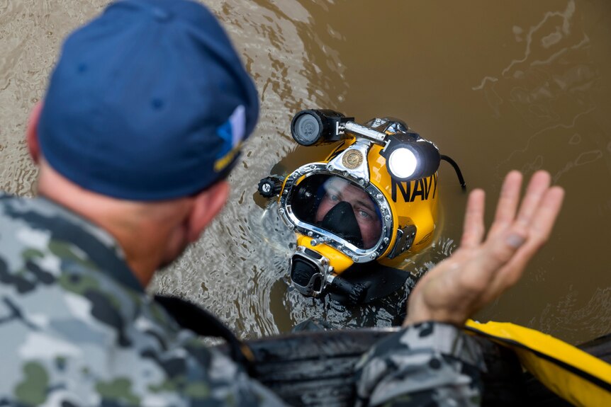 Navy sailor Able Seaman Clearance Diver Jake Phillips prepares to survey ferry terminal pylons along the Brisbane River.