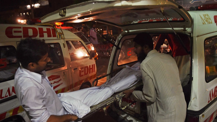 Relatives shift the dead body of a heatwave victim in Pakistan