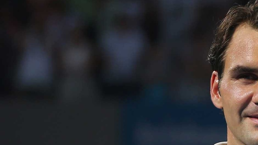Lleyton Hewitt (R) holds the 2014 Brisbane International trophy after beating Roger Federer (L).