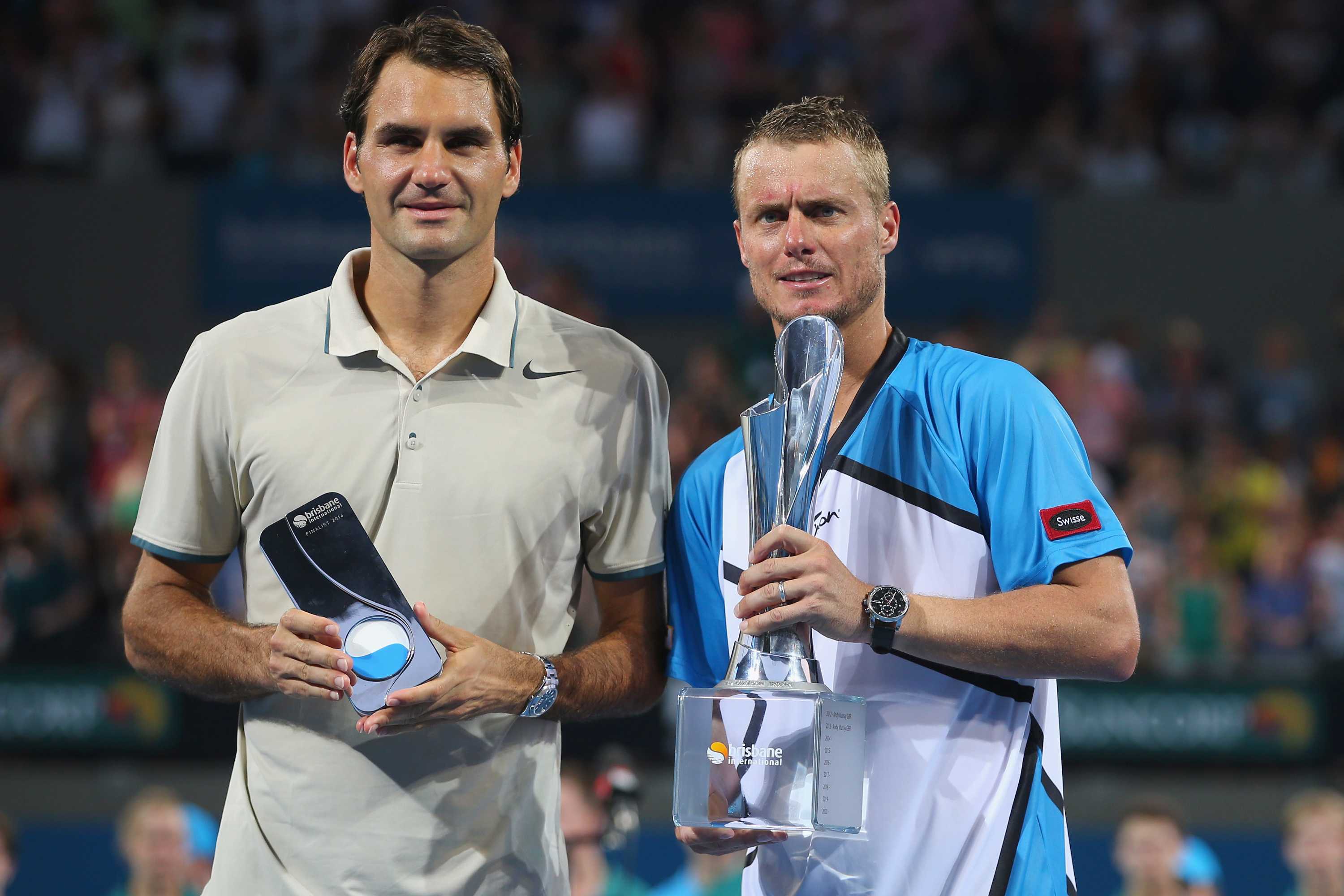 Lleyton Hewitt (R) holds the 2014 Brisbane International trophy after beating Roger Federer (L).