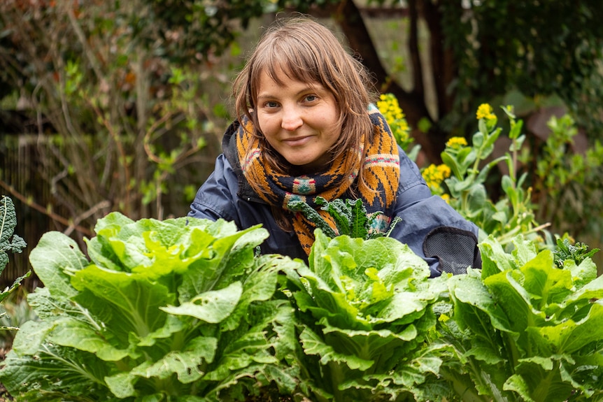 A woman with vegetables in produce garden.