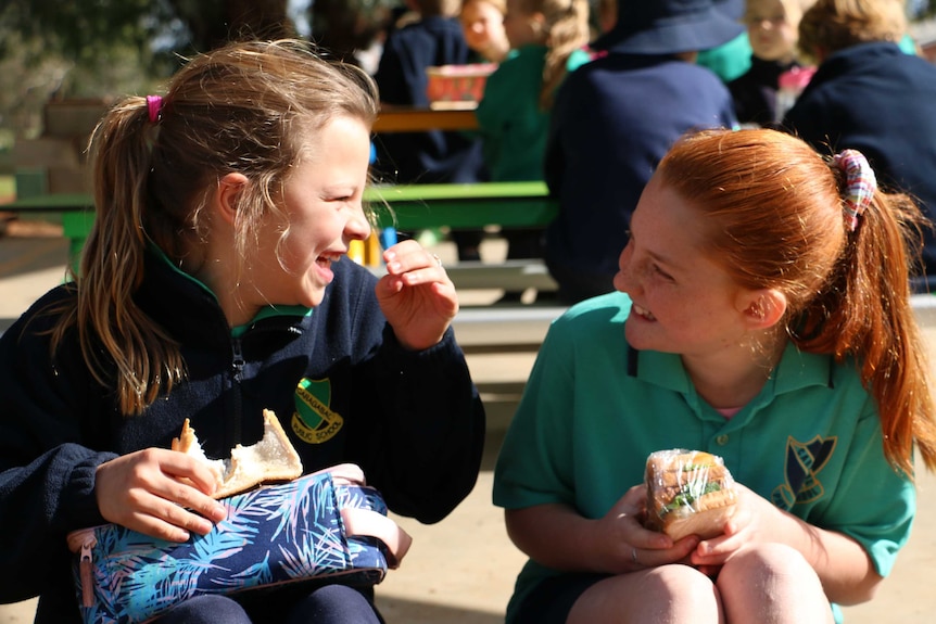 Two girls looking at each other and laughing