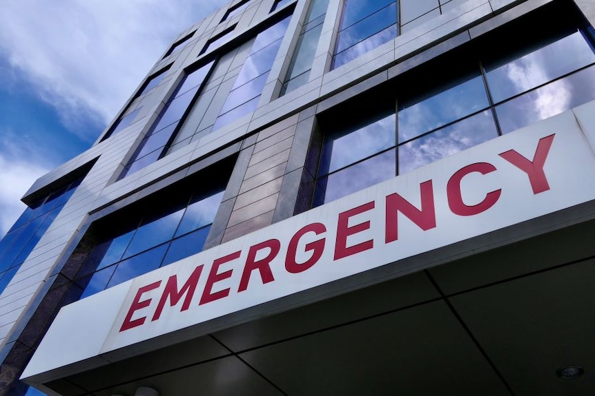 A multi-story building with an emergency sign on the front.