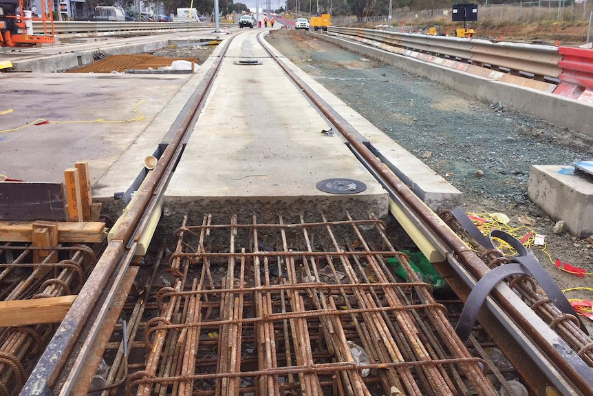 Light rail tracks under construction on an overcast day in Canberra.