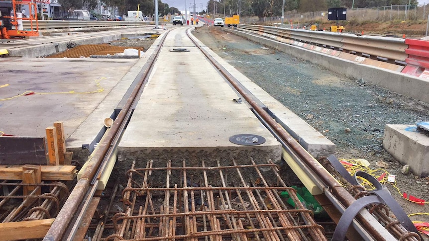 Light rail tracks under construction on an overcast day in Canberra.