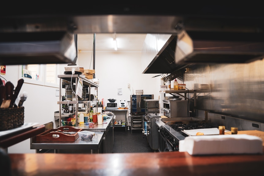 Large steel work benches and cabinets in a pub kitchen space.