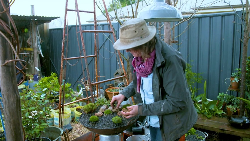 Gardening Australia's Millie Ross in the garden with a wok-cum-pot