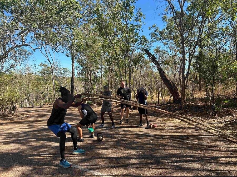 a group of young people exercising in the bush