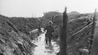 A soldier makes his way through a trench along the Western Front during WW1.