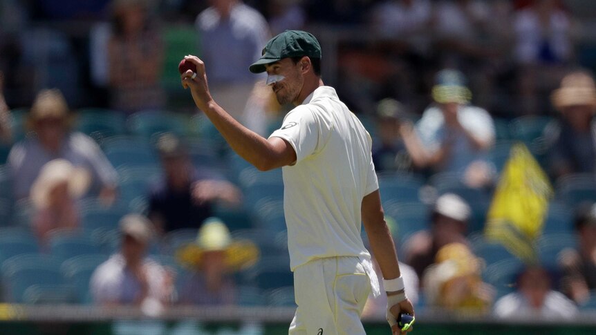 Mitchell Starc holds up the cricket ball after taking five wickets against Sri Lanka