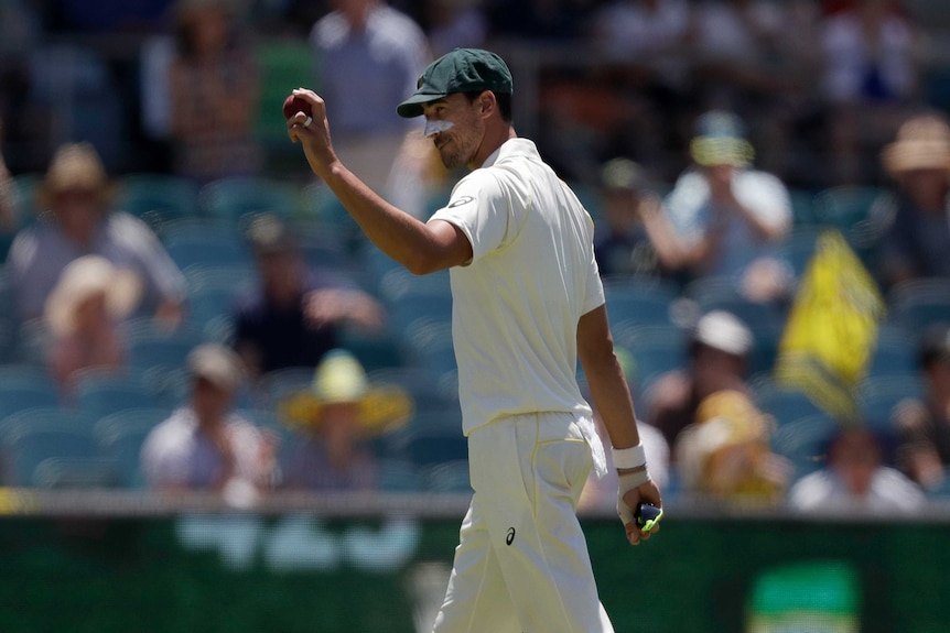 Mitchell Starc holds up the cricket ball after taking five wickets against Sri Lanka