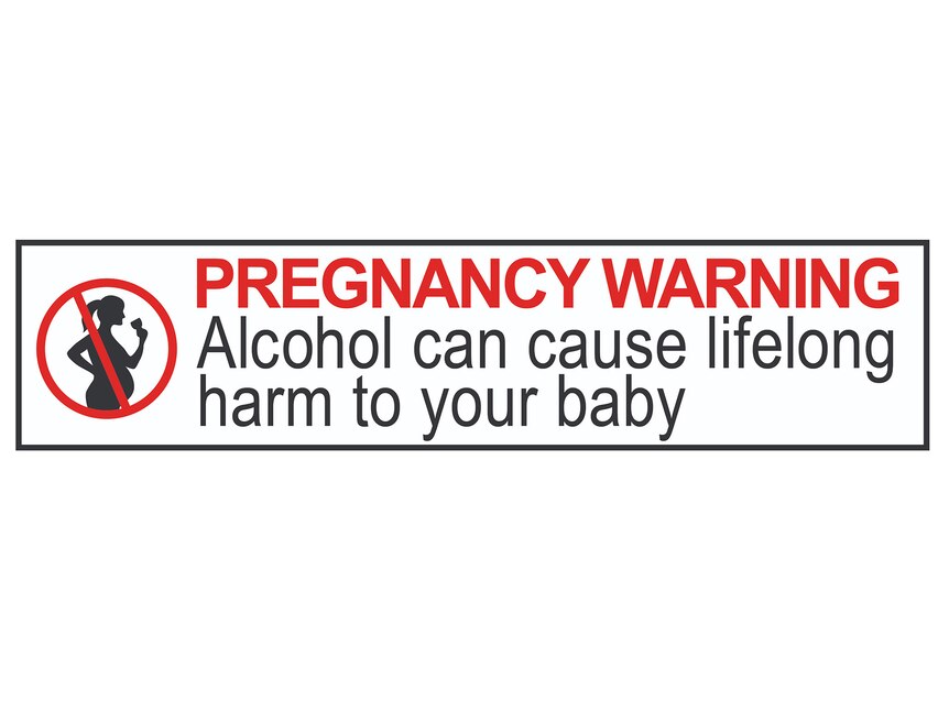A pregnancy warning label with large red and black lettering and a graphic of a woman holding a wine glass with a red strike 