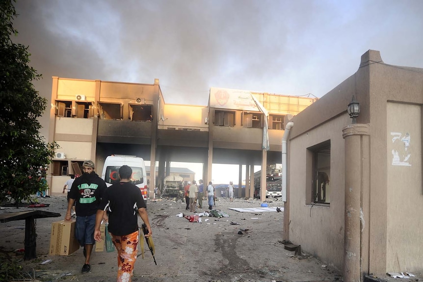 Rebels gather at a destroyed building in Abu Salim.