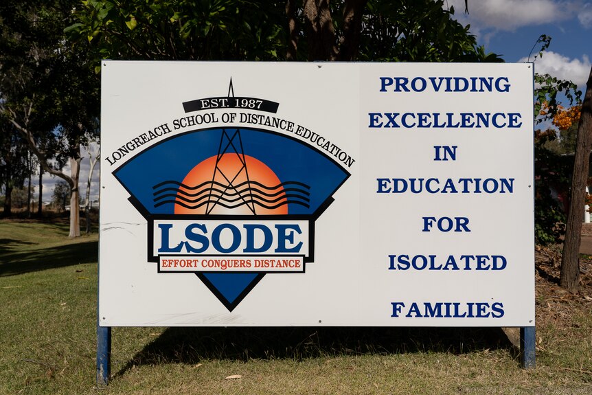 A sign outside a school that reads "providing excellence in education for isolated families".