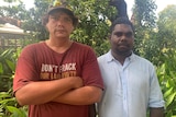 Borroloola resident Nicolas Fitzpatrick and traditional owner Conrad Rory face the camera standing in front of a house and tree.