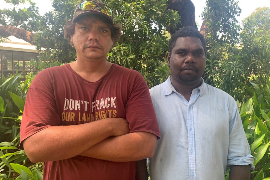 Borroloola resident Nicolas Fitzpatrick and traditional owner Conrad Rory face the camera standing in front of a house and tree.