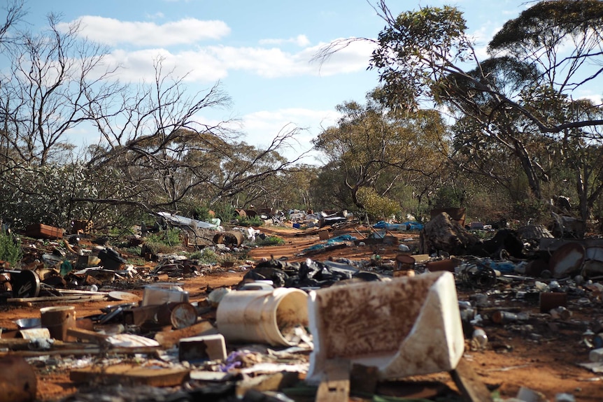 Rubbish, including buckets, plastic bags, old metal scrap and bottles, lay strewn for hundreds of metres in a national park.