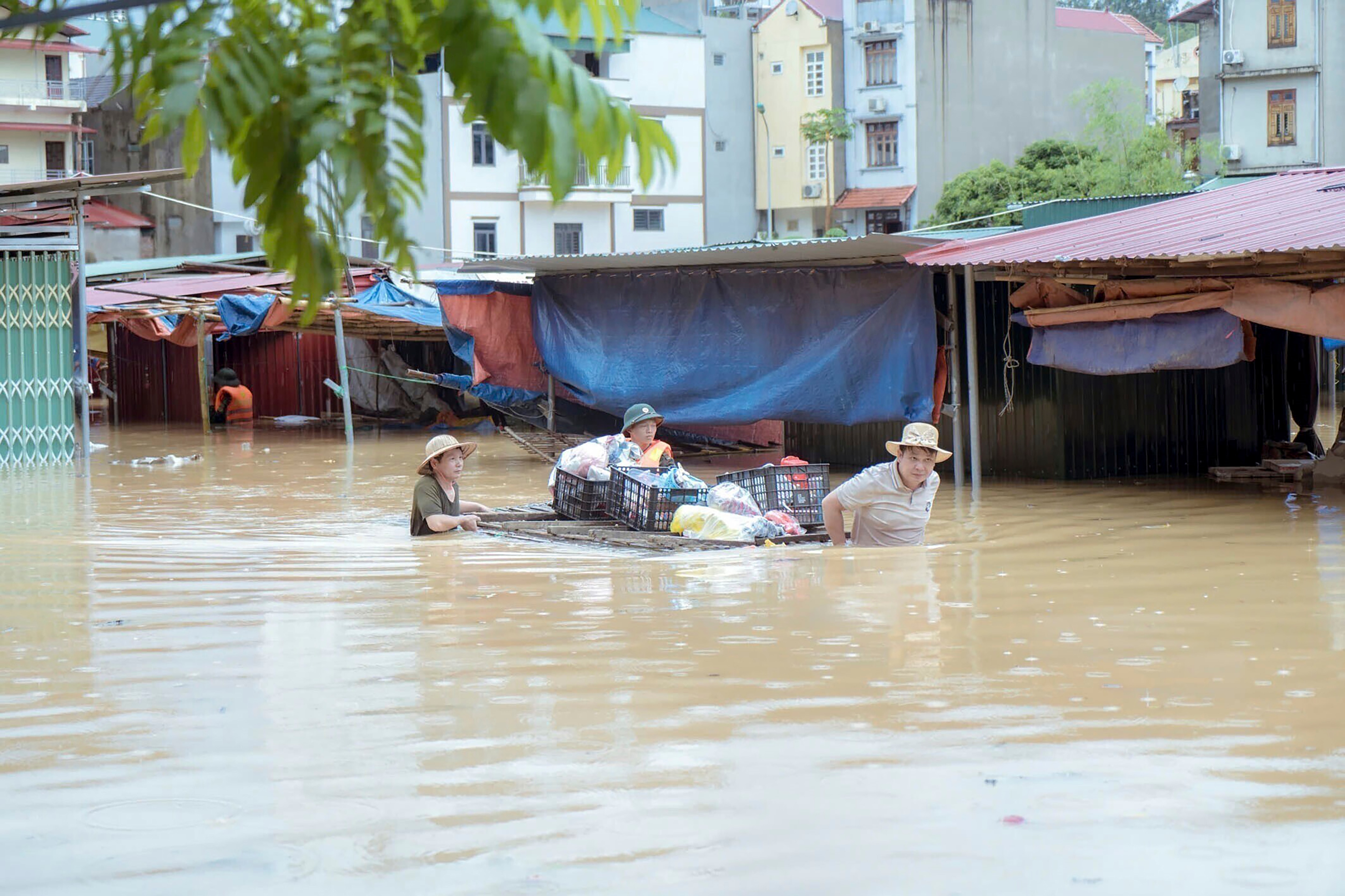 People wading through chest high floodwaters