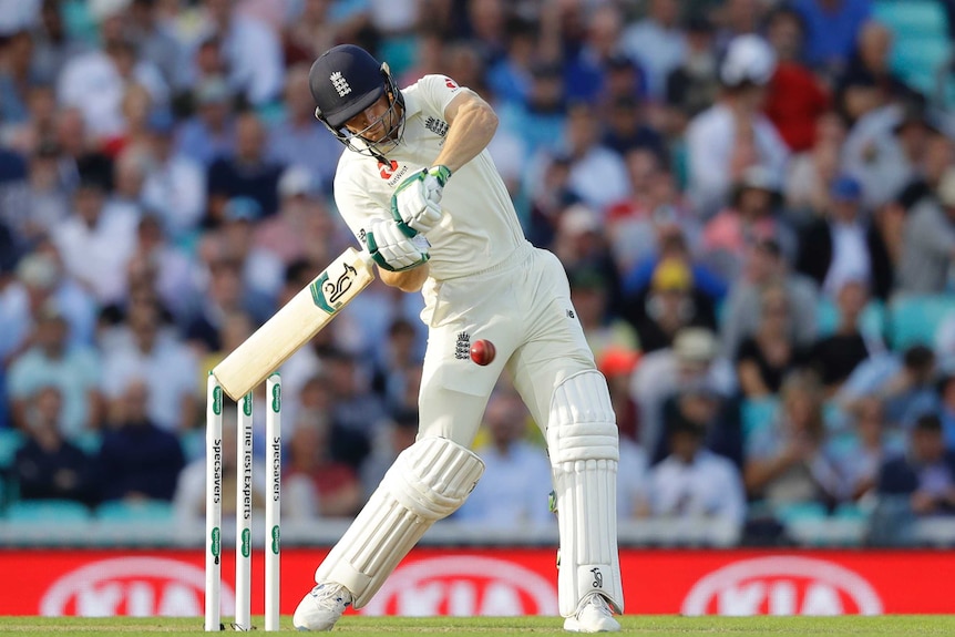 A batsman swings mightily at the ball as he hits a six.